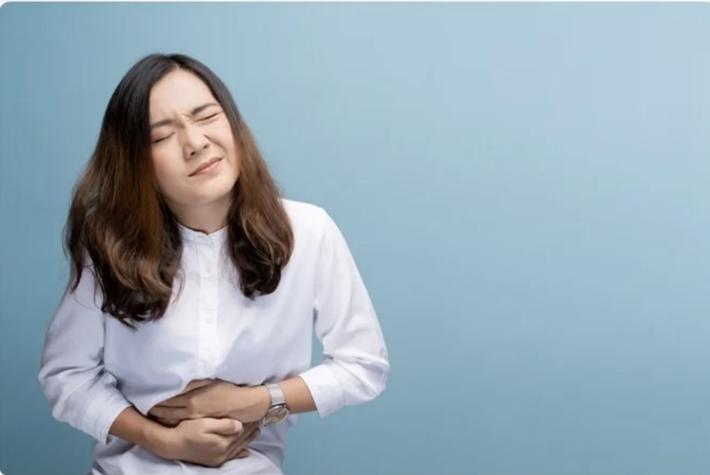 woman holding her stomach in pain